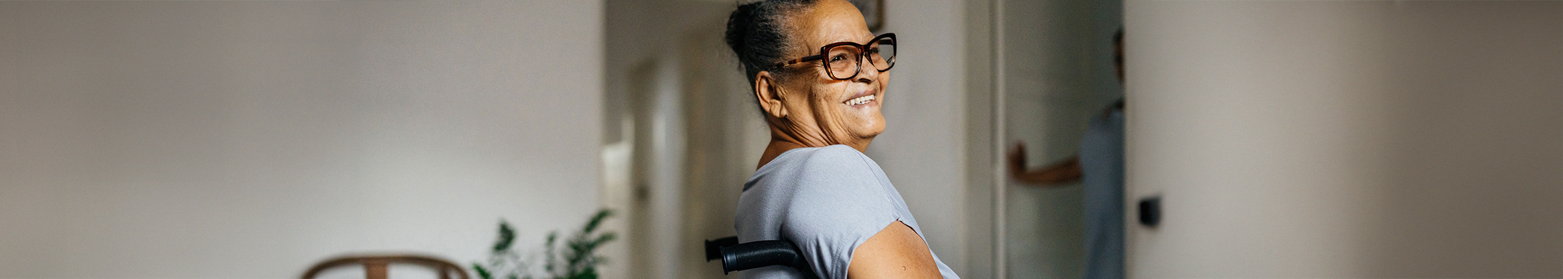 A woman sitting in a wheelchair smiling 