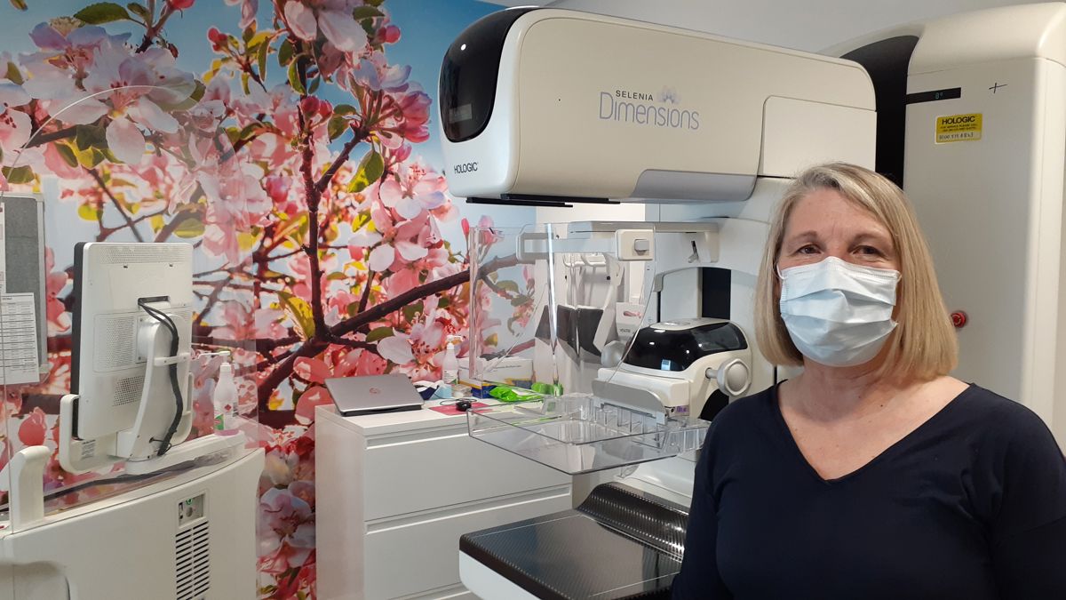 women standing in front of mammogram machine with covid mask